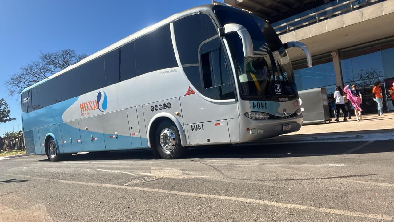 Ônibus da Suzan Turismo parado em área de embarque com passageiros